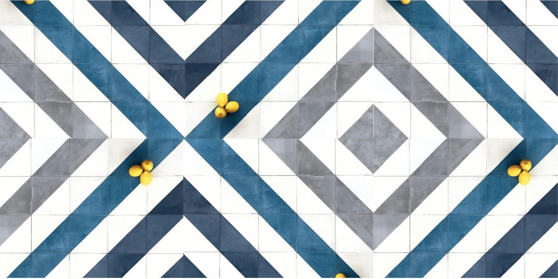 Piso de baldosas hidráulicas en triángulos azul, gris y blanco que forman rombos y chevrones