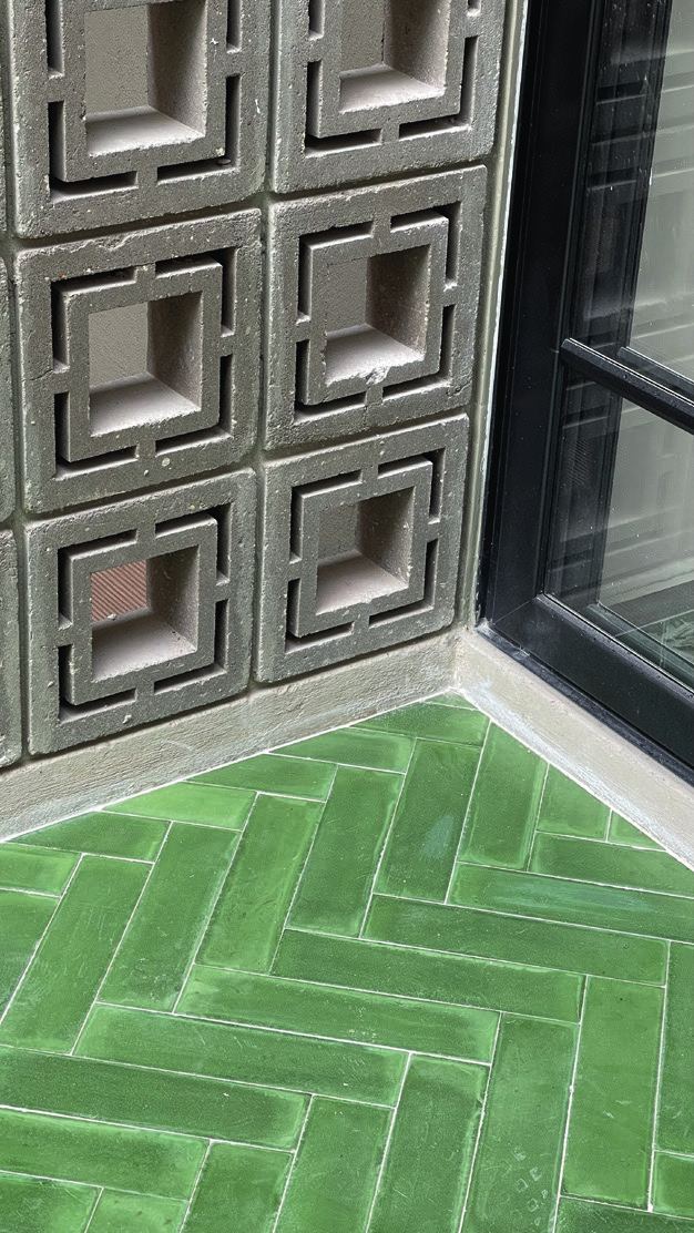 Celosía de concreto y piso verde en espiga